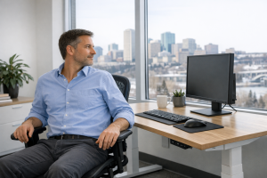 Office worker taking a movement pause at an adjustable computer workstation.